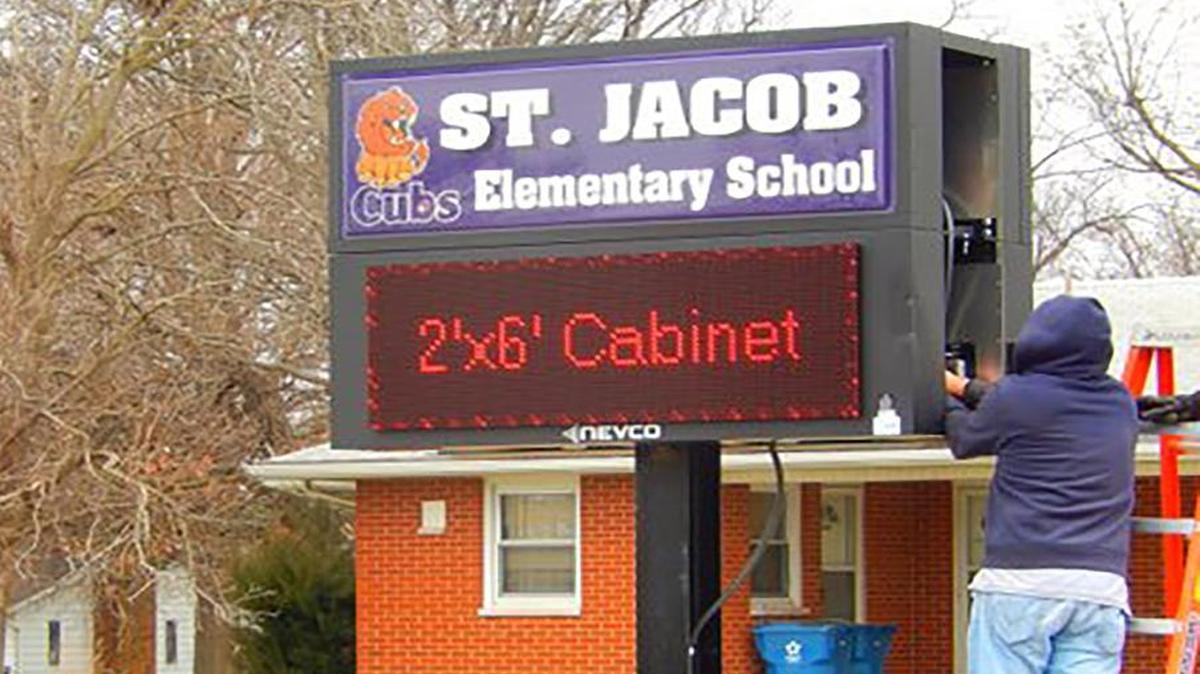 ST. JACOB ELEMENTARY GETS NEW MARQUEE A worker puts the finishing touches on a new electronic marquee in front of St. Jacob Elementary School. The St. Jacob BBQ Society donated $15,586 to the school in November for construction of the new sign. The money represented two years of proceeds from the society’s Jakey in June barbecue festival. Since its inception, the St. Jacob BBQ Society has donated more than $35,000 for various projects in the community. This year’s Jakey in June festival will be June 3-5.