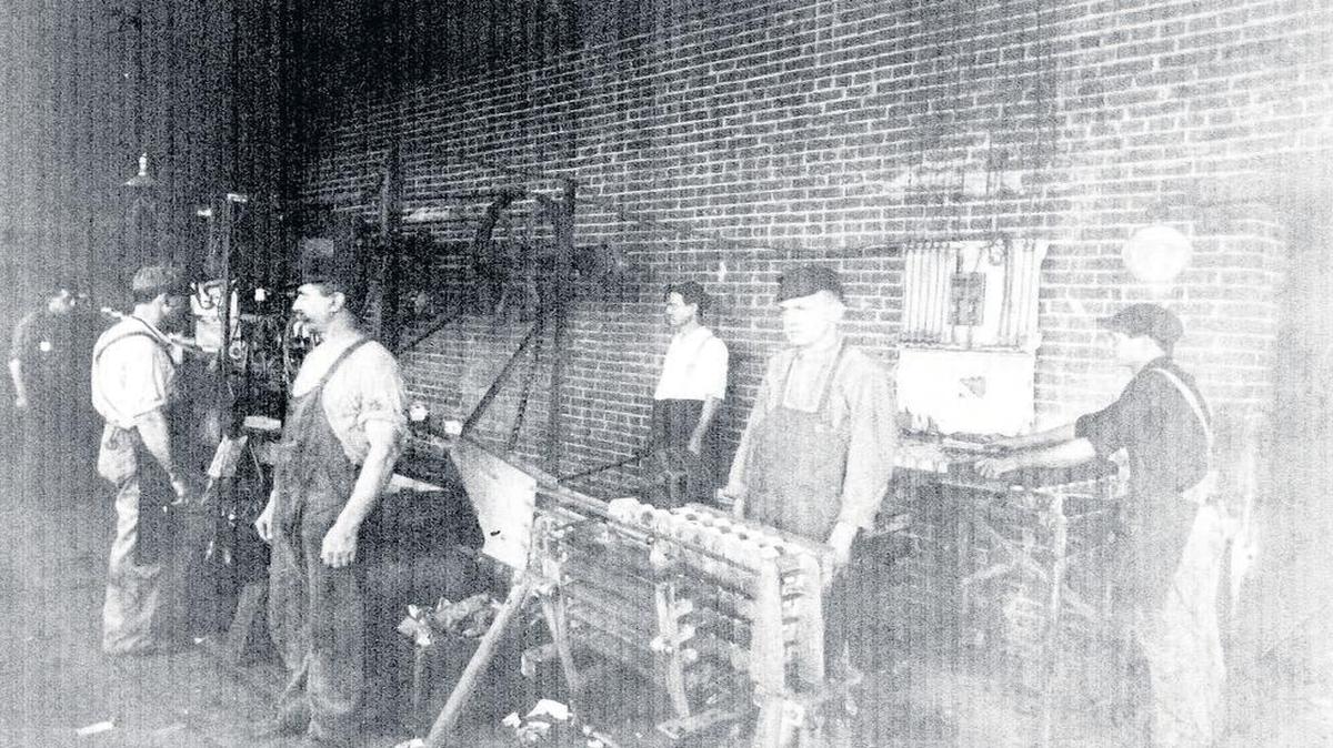 
This picture shows workers at the PET Milk plant in Greenville. Carl Hediger, third from left (man with mustache facing left), invented a can labeling machine. The machine is also pictured just to Hediger’s left. Photo was a gift from Eldon and Marilyn Neumann of Mulberry Grove.
