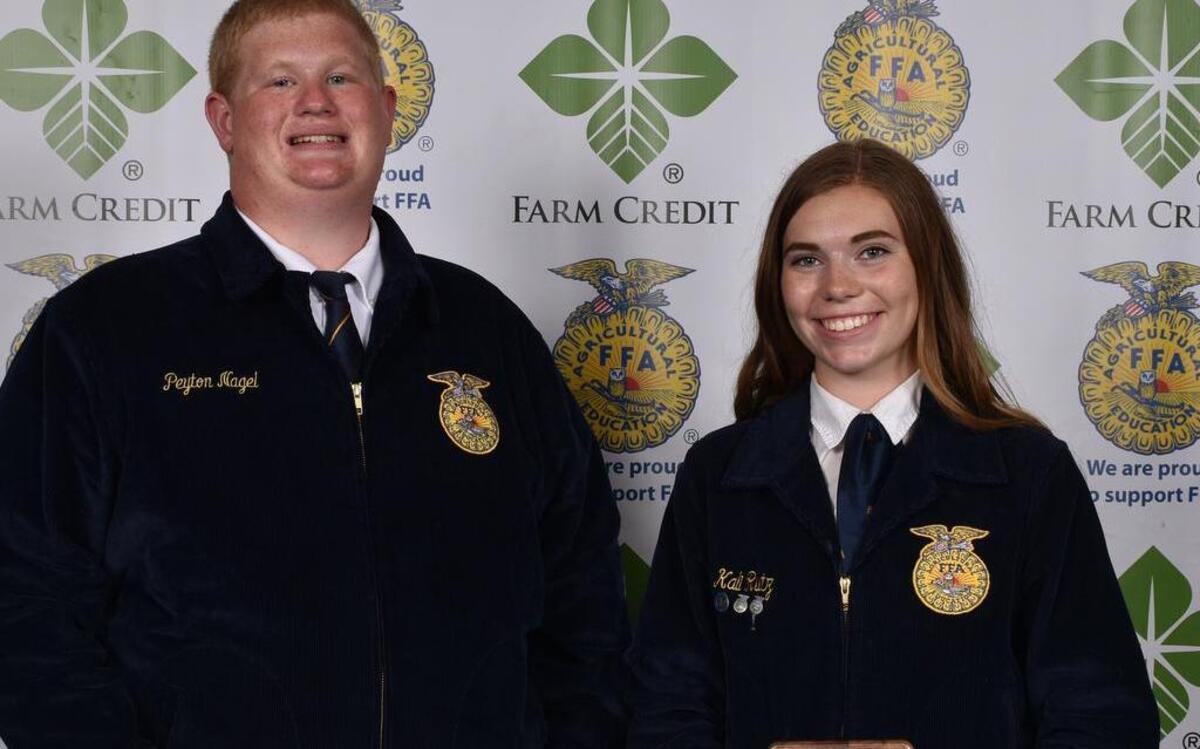 Peyton Nagel and Kali Rutz pose with one of the awards the Highland FFA chapter won at the 89th annual Illinois State FFA Convention.
