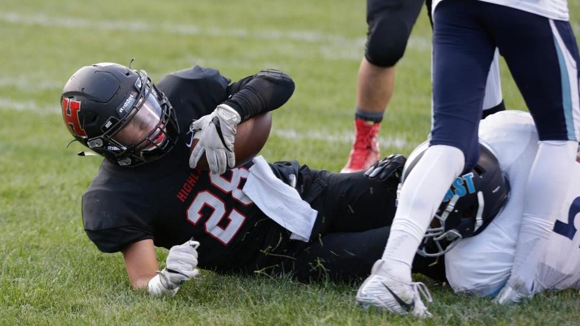 Highland’s Brady Feldman hits the grass after scoring a touchdown during the game with Belleville East on Friday. A group would like to replace the grass field with turf, but the superintendent says he doesn’t support the plan.