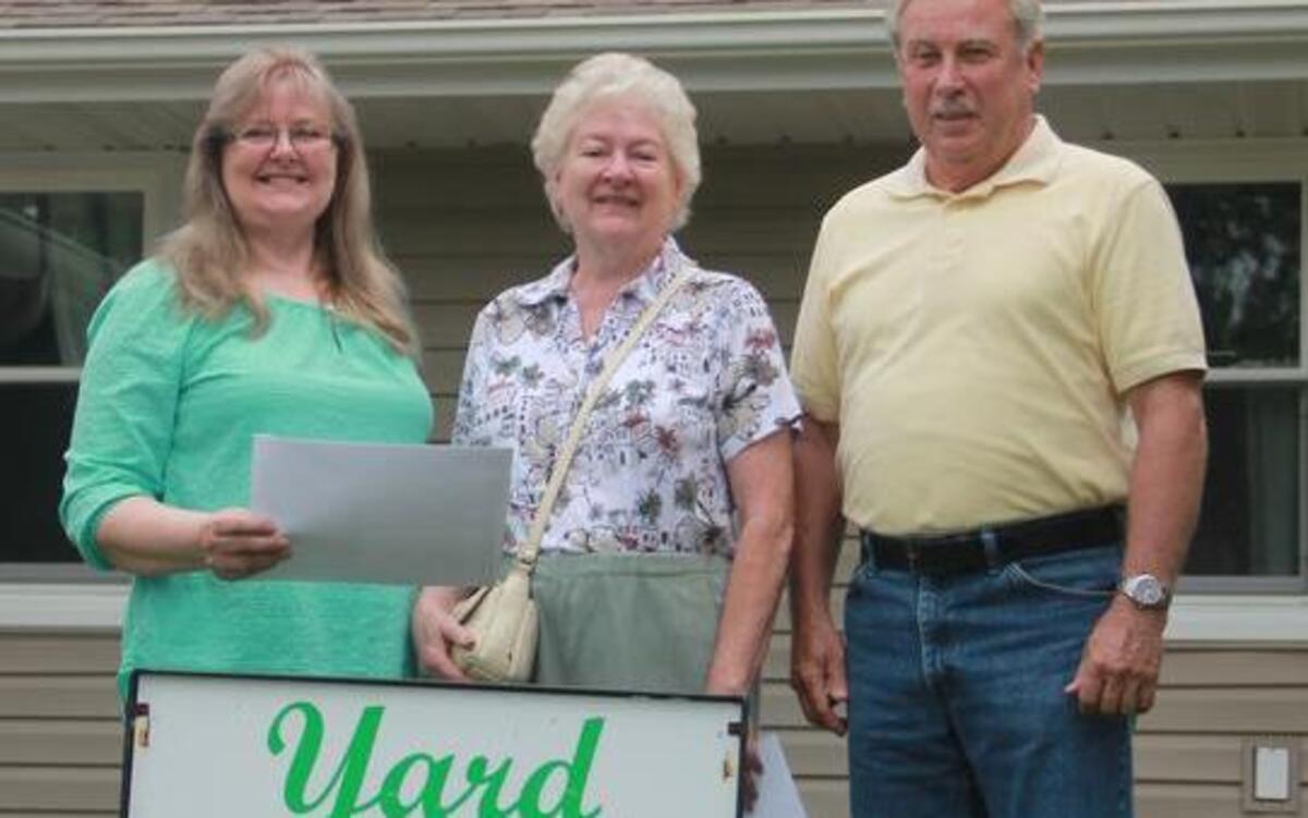 
Dottie, left, and Gary Graves, right, of 2411 Poplar have Highland’s Yard of the Month for July. Also pictured is Judy West of the Highland Garden Club.
