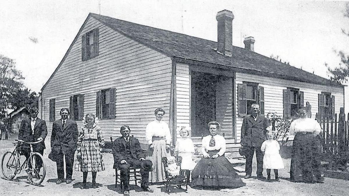 The John and Anna Bader Donnelly Farm Home on Giger road at Lower Marine Road: This farm originally belonged to John and Anna Gilgen Bader Sr. It was next owned by John and Matilda Branger Bader Jr., then by their daughter, Mrs. Anna Bader (John M.) Donnelly. In the photo, from left, are Harry Donnelly (with bicycle), Thomas Donnelly, Florence Tischauser (foster child of John and Anna Bader Jr.), John M. Donnelly (seated in chair), Irma (Mrs. Thomas) Donnelly (standing), Irene Biggs (foster child of John and Anna Bader Jr.), Anna Bader (Mrs. John) Donnelly (seated); then at the far right is John Bader Jr. and Vera Biggs (foster child) and Henrietta, (second wife of John Bader Jr.).