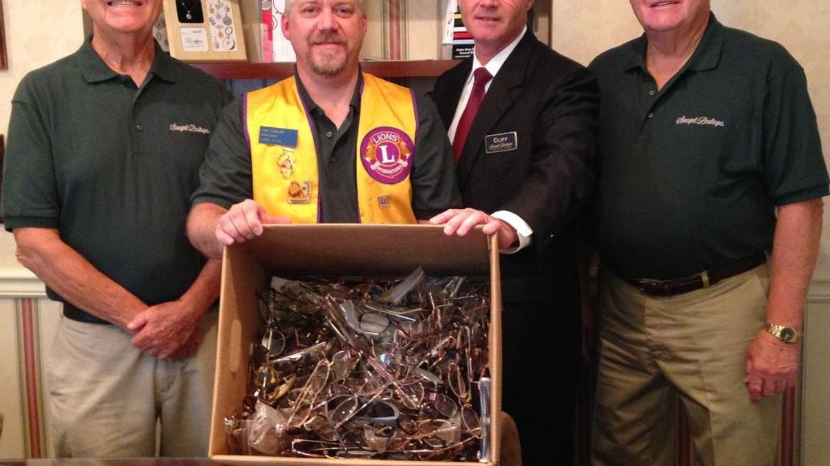 
Funeral Director and Highland Lions Club Member Thomas Fowler accepts 275 pairs of eyeglasses and 25 sets of hearing aids from fellow Lions and Funeral Home Representatives Biddy Essenpreis and Gene Redman, and Funeral Director Clifton Couch for donation to the “Recycle for Sight” and HARP programs sponsored by Lions Club International.
