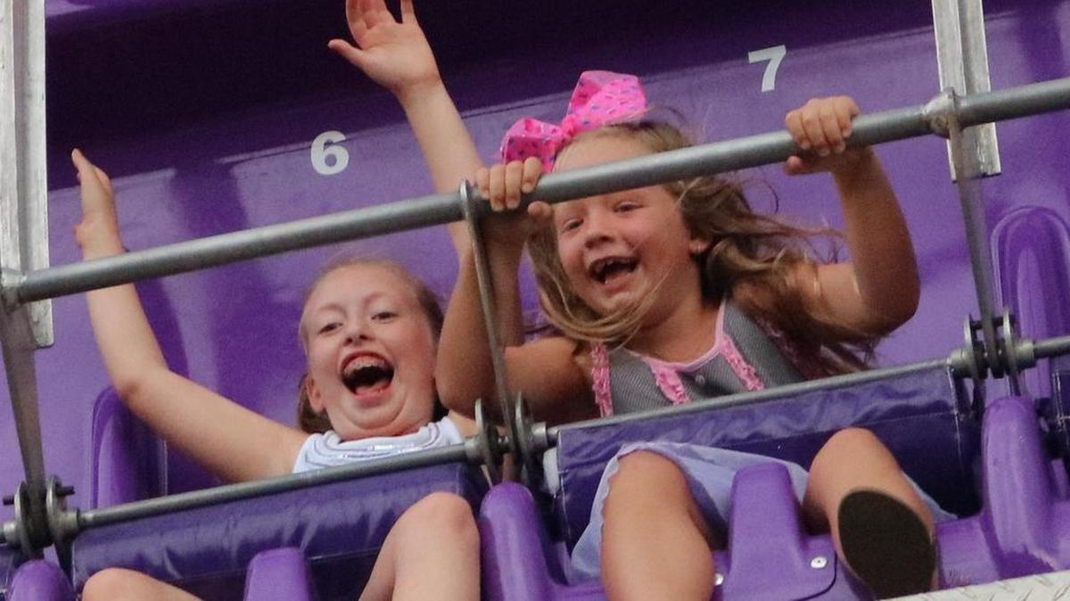 Kara Littlefield, left, and Violet Hallowell, right, laugh during a ride at the St. Jacob Homecoming Family Night last year.