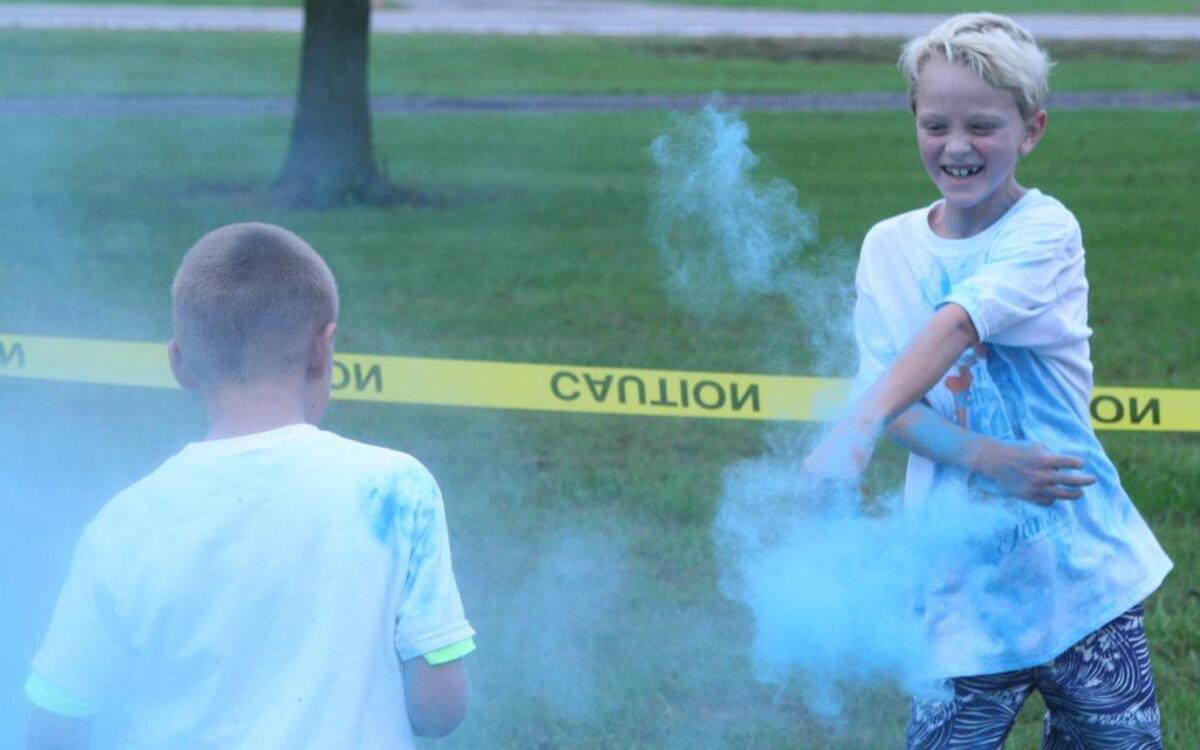 Brant Masholt (left) and Oliver Lewis (right) throw paint dust on each other after finishing the color run.