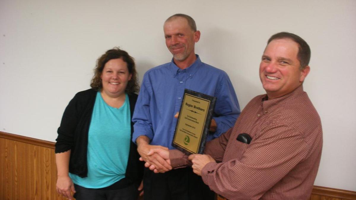 Kim and Tim Rogier accept the Outstanding Progress in Soil and Water Conservation from Madison County Soil and Water Conservation District chairman Ken Rinkel.