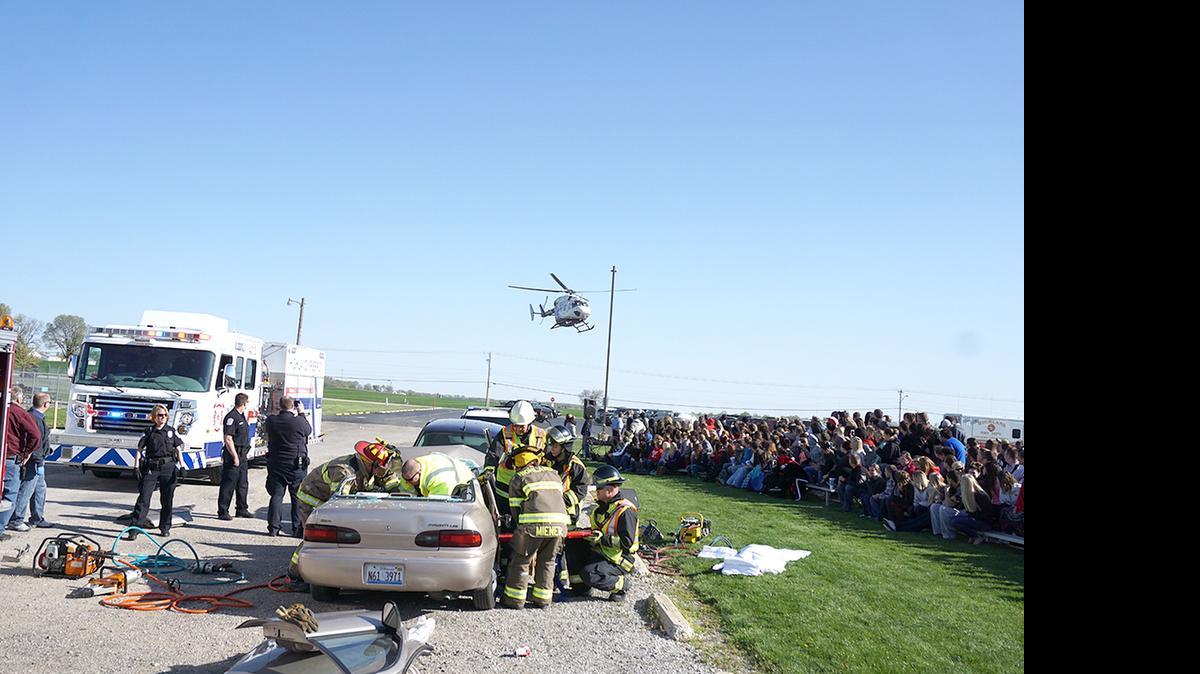 
Firefighters work to extricate a ‘victim’ during a mock crash last week at Highland High School as students watch.
