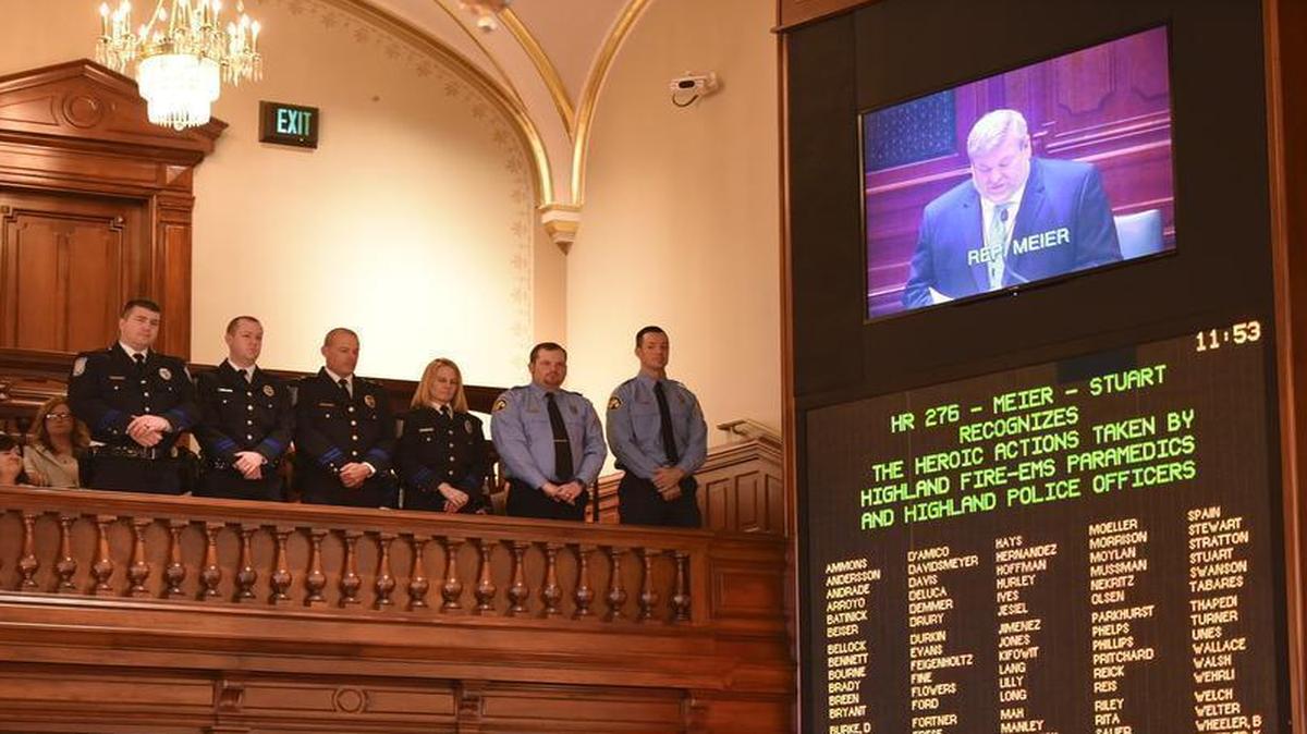 From left, HPD officers Chris Clewis, Shawn Bland, Sgt. Aric Steinbeck and Heather Kunz, along with Highland paramedic Ty Barr, Paramedic Todd Zobrist listen from the balcony as state Rep. Charlie Meier reads a resolution in the Illinois House of Representatives honoring the first-responders for their roles in rescuing a baby from a submerged vehicle in Silver Lake on March 16.