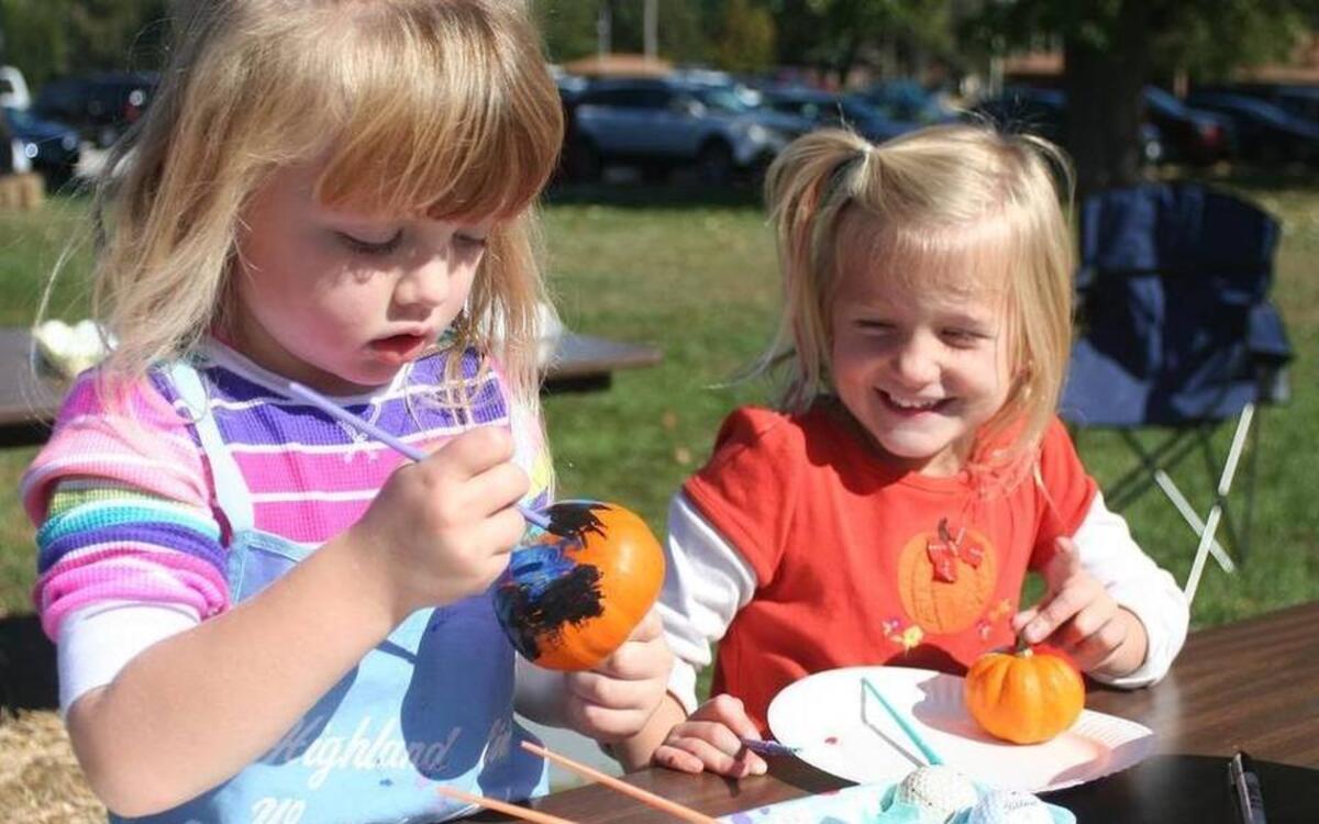 Camille Kunz and Chloe Holthaus paint pumpkins at the Highland Civic Woman Club’s PumpkinFest last year.