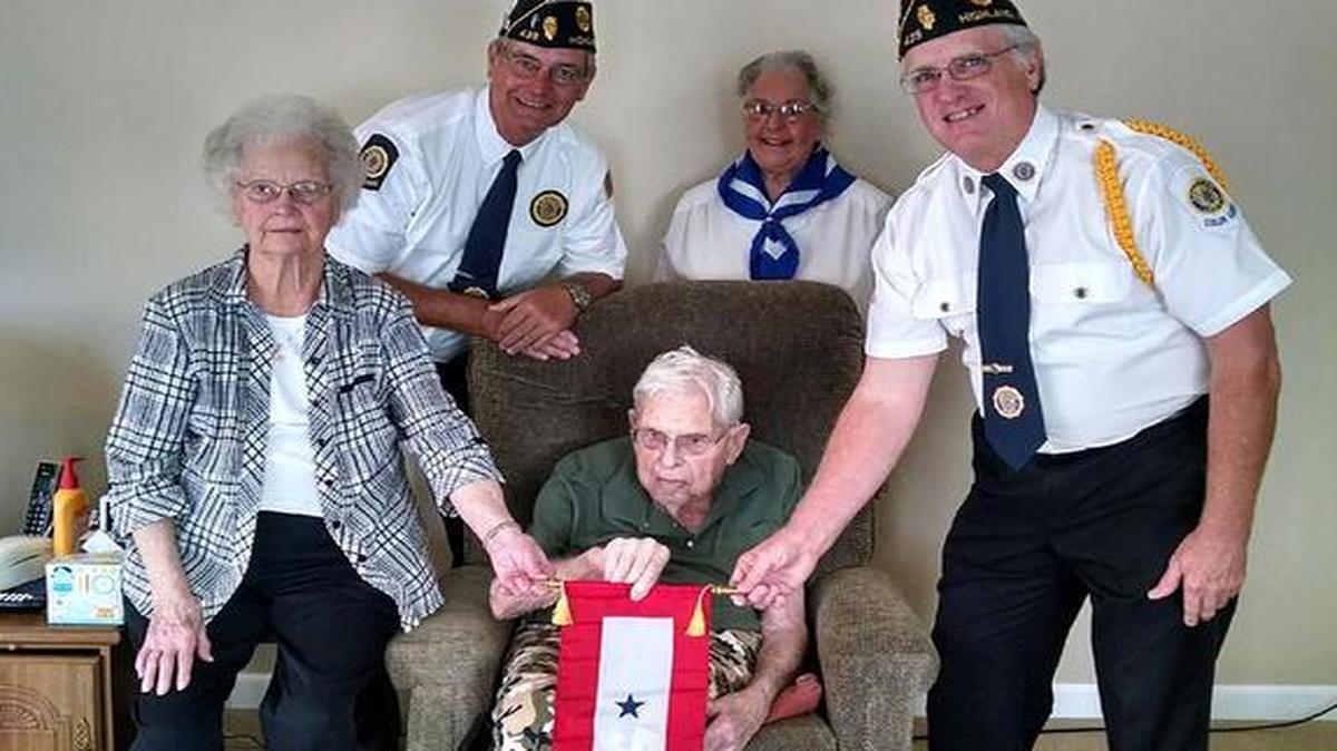 Marie and Clarence Plocher, seated, accept a Blue Star Banner from Post 439 representatives, from left, Phil Chapman, Jeanette Hammel and Jim Hobbs.