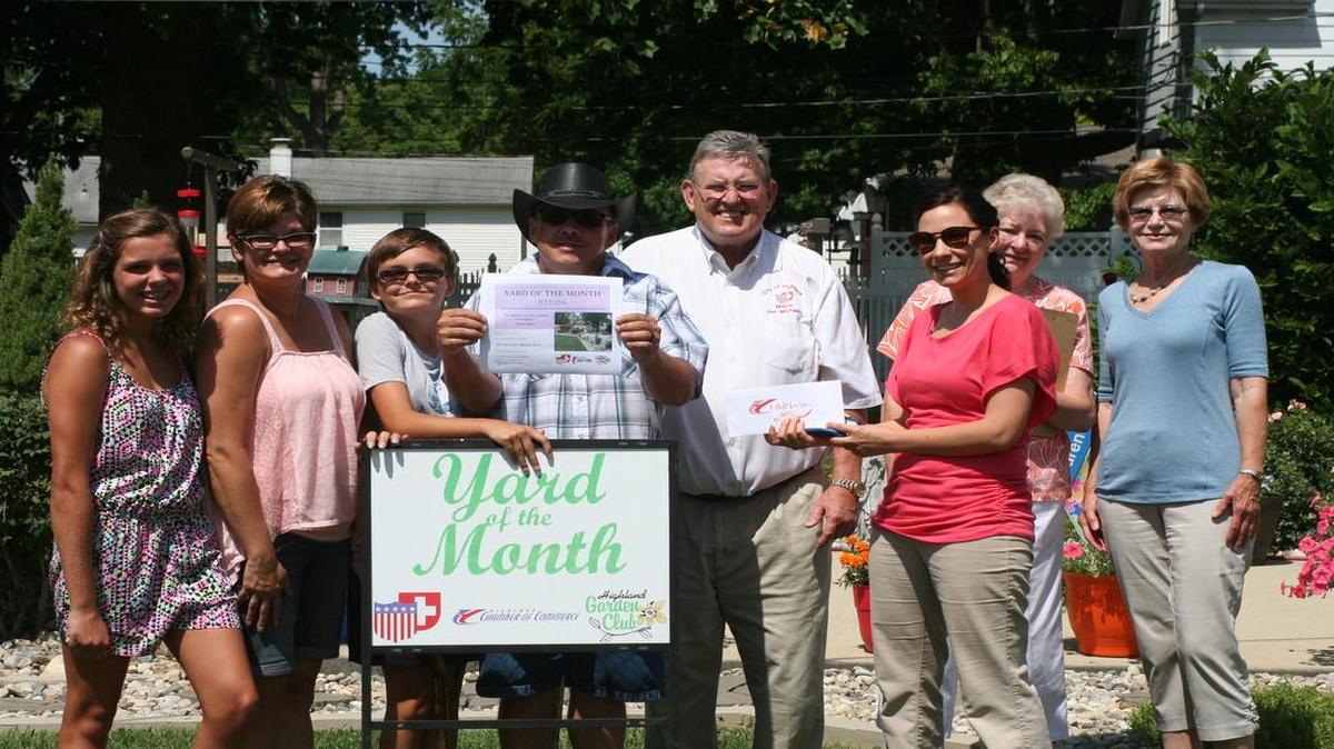 July’s Yard of the Month winners are Joe and Karen Hess, who live on 13th Street. From left are Olivia Hess, Karen Hess, Emily Hess, Joe Hess, Highland Mayor Joe Michaelis, Highland Chamber of Commerce Director Nancie Zobrist, Carol Wieduwilt, and Judy West as they pose for a photo.