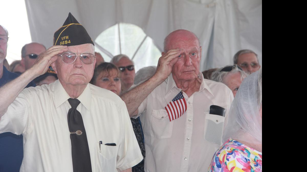 
Roland Harris and Marvin Sackett salue the flag while the Highland High School band plays the Star Spangled Banner.
