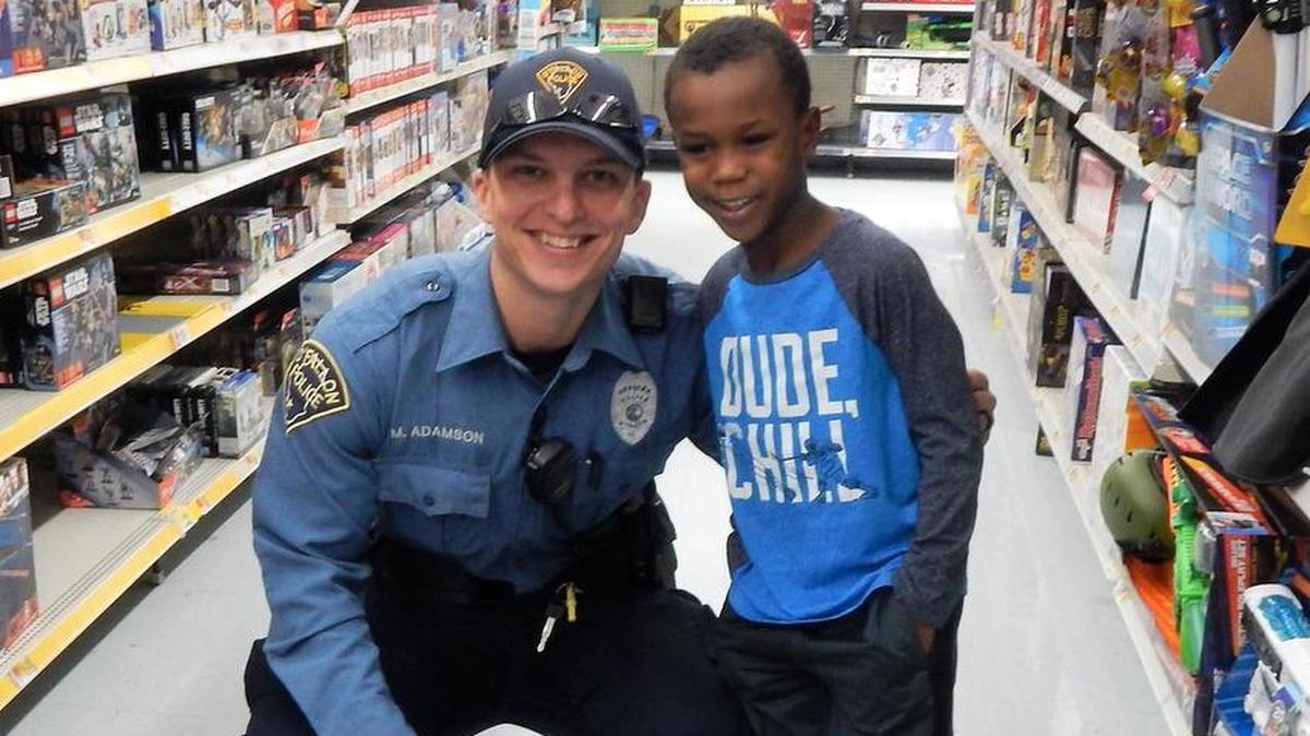 Matt Adamson shops with Tyrez, 6, during OPD’s Christmastime Cops and Kids event at Walmart.