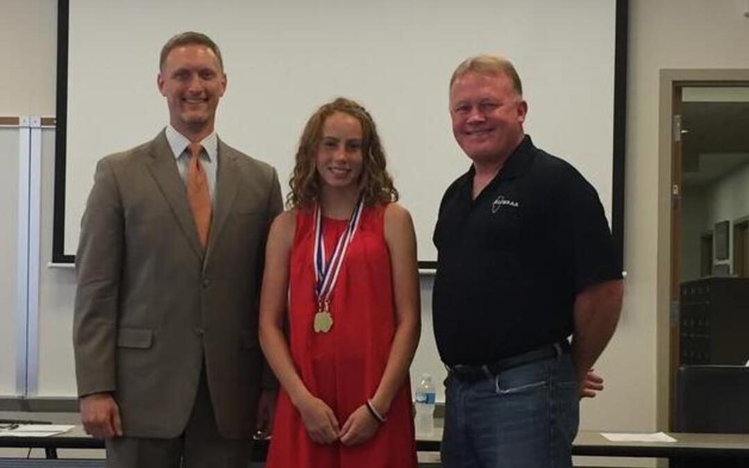 From left, O’Fallon School District 90 Board President John Wagnon, and Aubrey Mister, who received the Jim Burnes Leadership award but was also honored in several track events recently, and O’Fallon CCSD 90 Athletic Director Tracy Lauderdale during Tuesday, June 20 board meeting.
