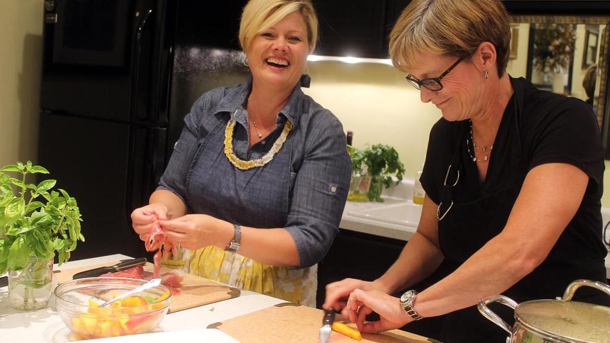 
Fezziwig's co-owner Ellen Leaf-Moore, left, and Suzie Dubose, a culinary volunteer, prepare fresh peaches with prosciutto ham and basil before guests arrive for a class.
