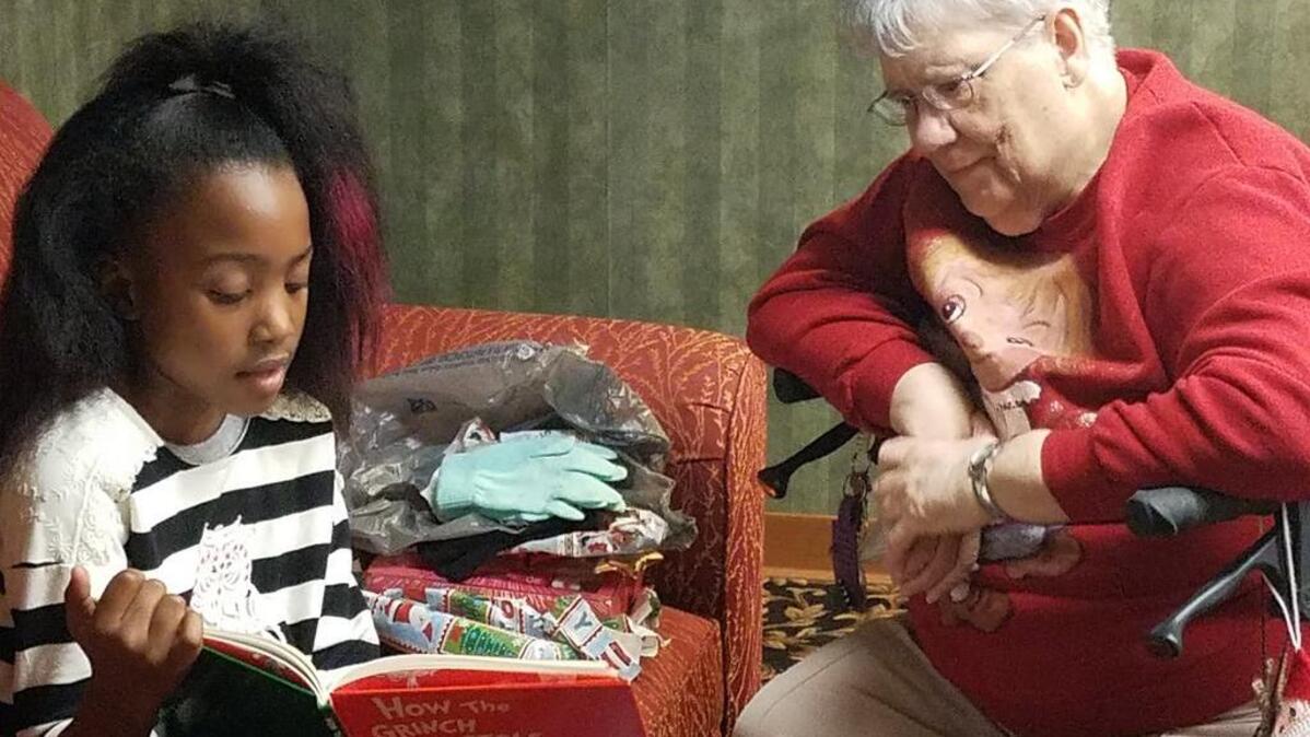 Moye Elementary student Ashlynn Richardson reads a Christmas story to Louisa Wagner, a resident of Cambridge House in O’Fallon.