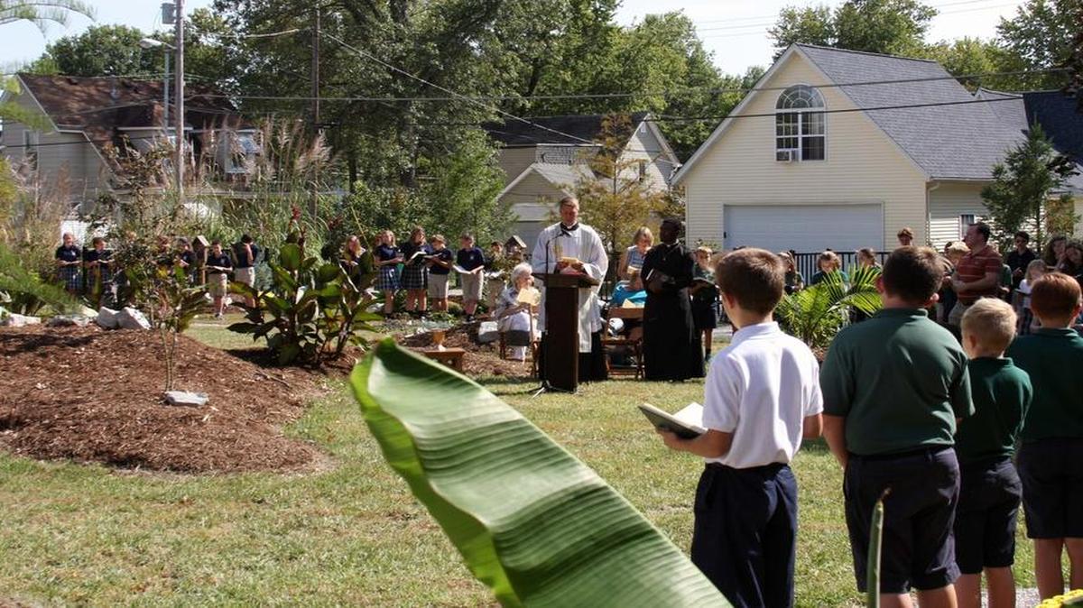 Father Jim Deiters, pastor of St. Clare of Assisi Catholic Church in O’Fallon, leads the dedication ceremony for the church and school’s new neighborhood garden.