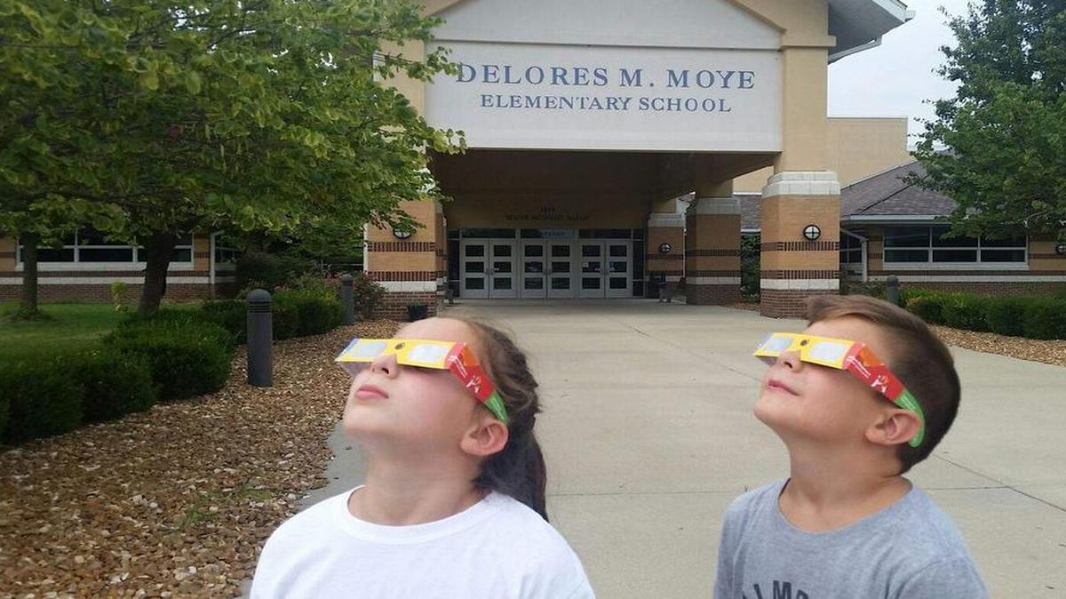 O’Fallon Community Consolidated School District 90 students Paige and Scott Stoelzle practicing using their new eclipse protective glasses in front of Delores Moye Elementary School. They are the children of Rob and Julie Stoelzle, district 90 teachers.