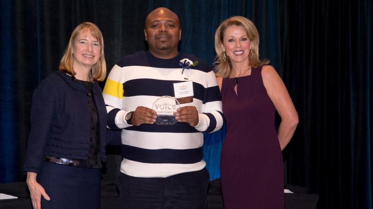 VOYCE executive director Mary Lynn Donovan, on left, and event emcee Cindy Preszler, right, present Lorenzo Coleman of O’Fallon with the Caregiver of the Year award during the 23rd annual VOYCE Caregiver Awards Luncheon.