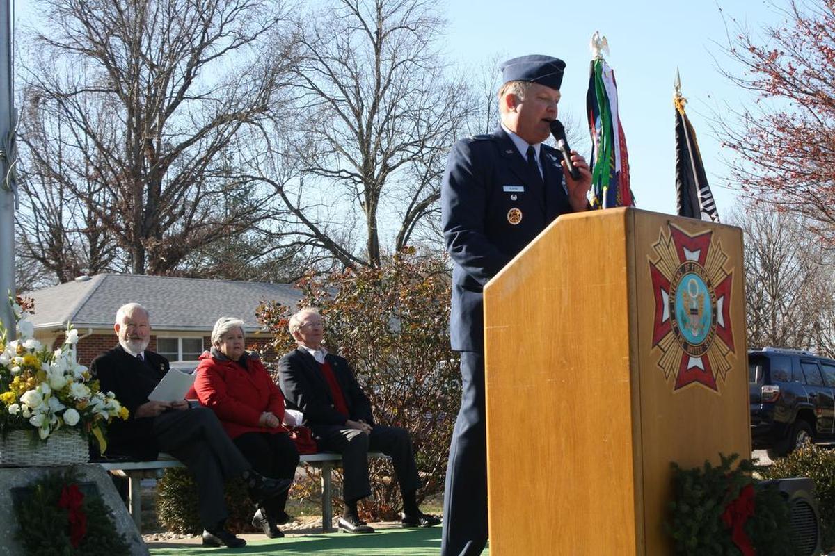 U.S. Air Force retired Col. John “Woody” Almind addresses attendees during the Wreaths Across America ceremony Saturday, Dec. 16 at O’Fallon Cemetery sponsored by the O’Fallon Rotary Club, Veterans of Foreign Wars, O’Fallon Fraternal Order of Police, Bob Eckert, The Egg & I, Schildknecht Funeral Home and many more. Sitting left, is USAF retired Col. Phil Goodwin, Mary Alice Koriath, of the O’Fallon Noon Rotary Club, and O’Fallon Mayor Herb Roach.