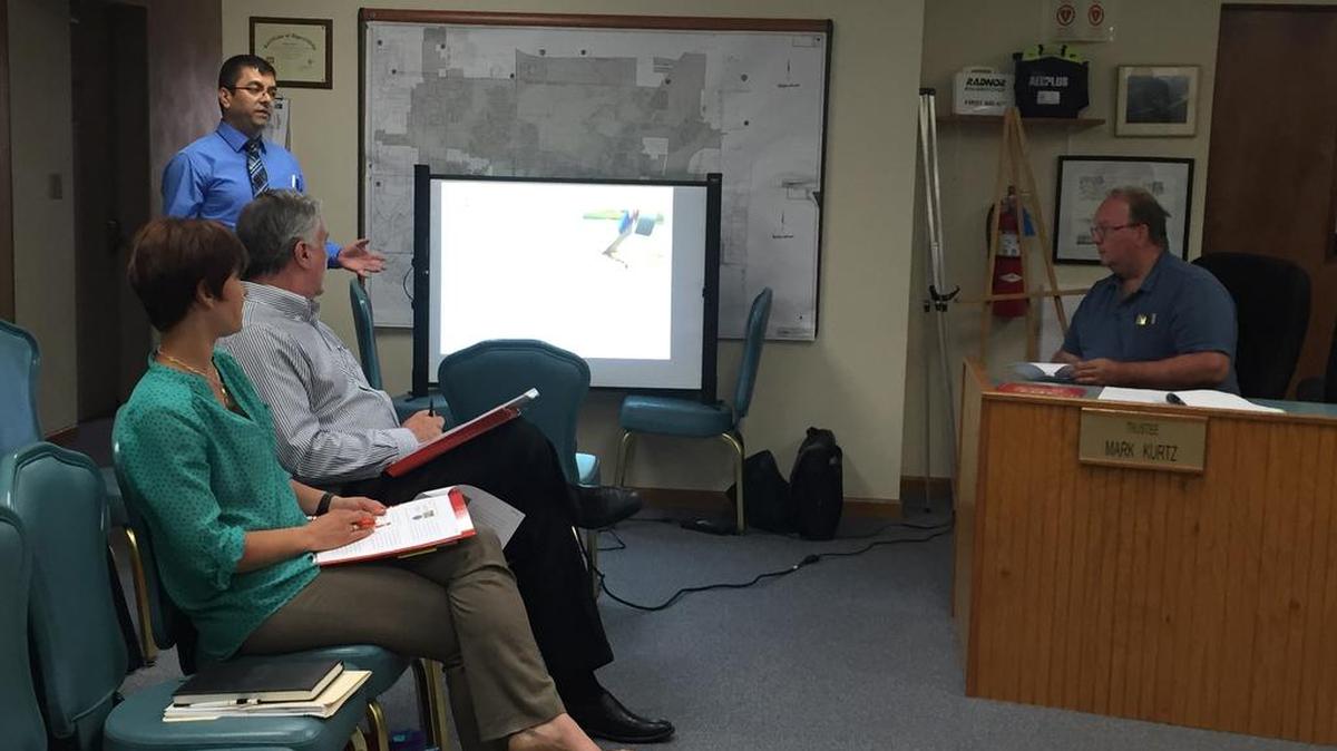 Karzan Bahaaldin, project engineer with Thouvenot, Wade & Moerchen Inc. stands to give a presentation about the benefits of a Pavement Management program and a Geographic Information System (GIS) database on Monday (May 23) at the Village Board of Trustees Committee at Large meeting in Village Hall at One Park Drive in Shiloh. From left sits, Village Public Works Director Megan Fuhler and Village Administrator John Marquart and, far right, Trustee Mark Kurtz.
