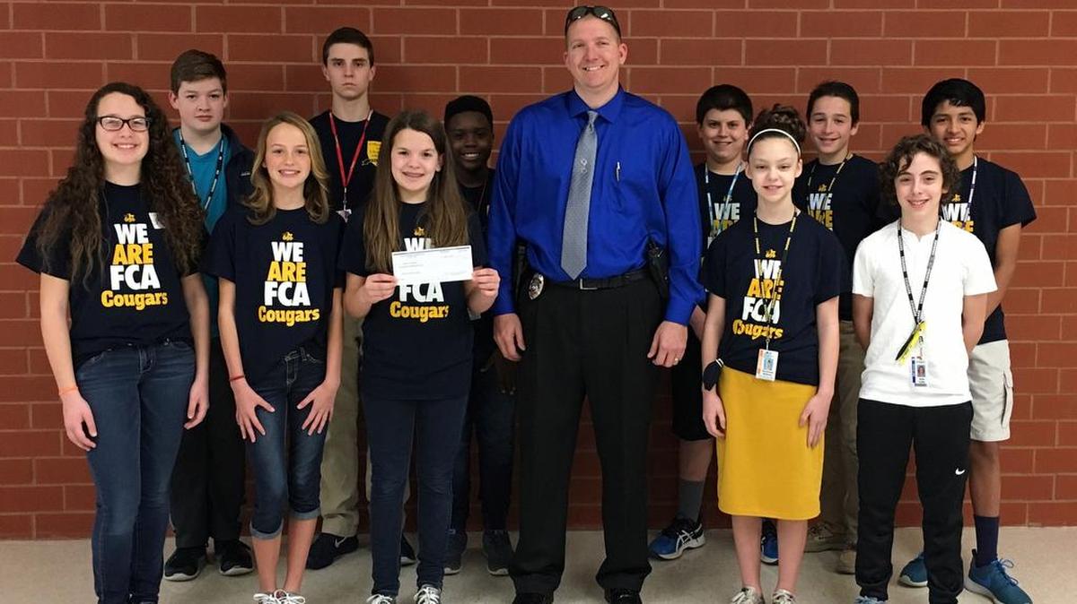 Carriel Jr. High School's Fellowship of Chrisitan Athletes and Scholar Bowl Team teamed up to help raise money for the O'Fallon Police Department’s Torch Run fundraiser for the Special Olympics. The Carriel student organizations sponsored a pajama pants and hat day where students and staff could pay $1 dollar each to wear the items on those days. If you participated you also received a raffle ticket for a variety prizes. Carriel was able to raise $310 for the O'Fallon Police Department. Featured in the pictures are Special Olympian Jenny Harper with the Torch and Officer Brian Gimpel of the OPD accepting the check.