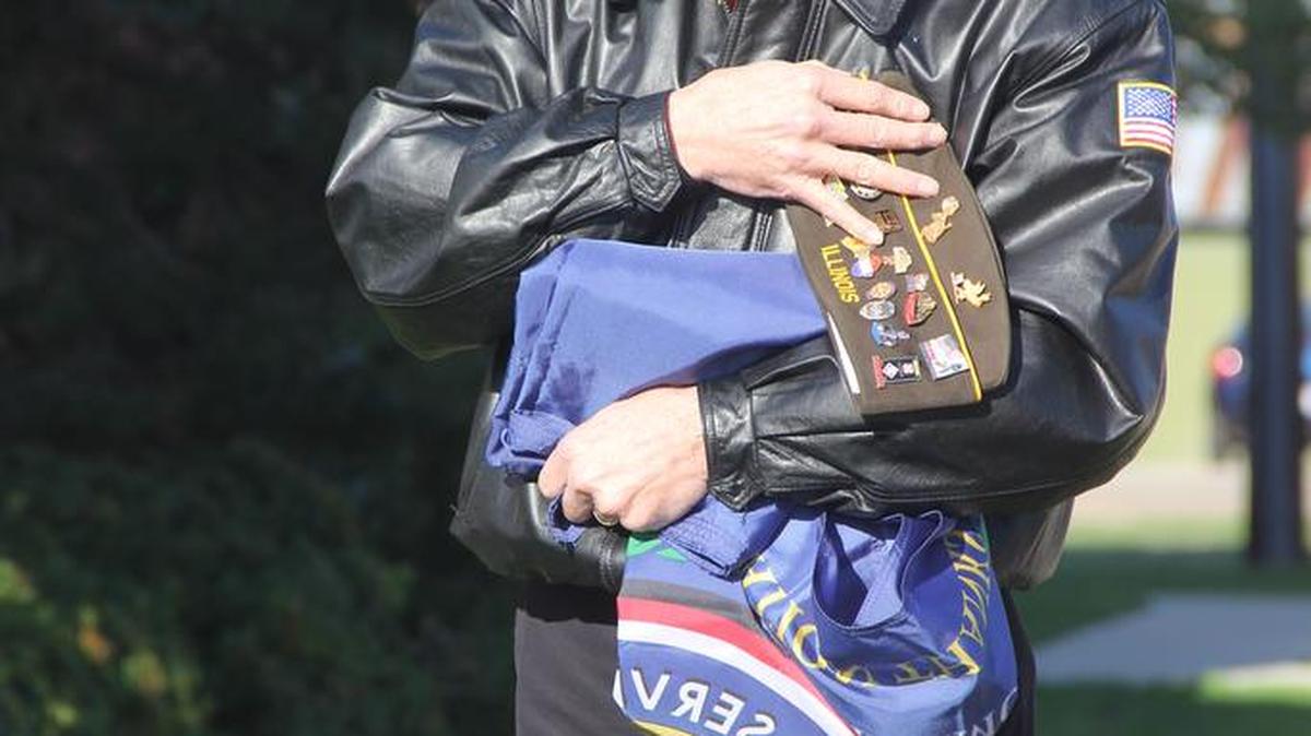 Remembering Vietnam Vets... Carl Stratton of Madison prays on a Vietnam flag before it is raised during a ceremony Tuesday morning recognizing Vietnam War veterans at O’Fallon City Hall. Stratton served in the U.S. Army from 1968-1992.