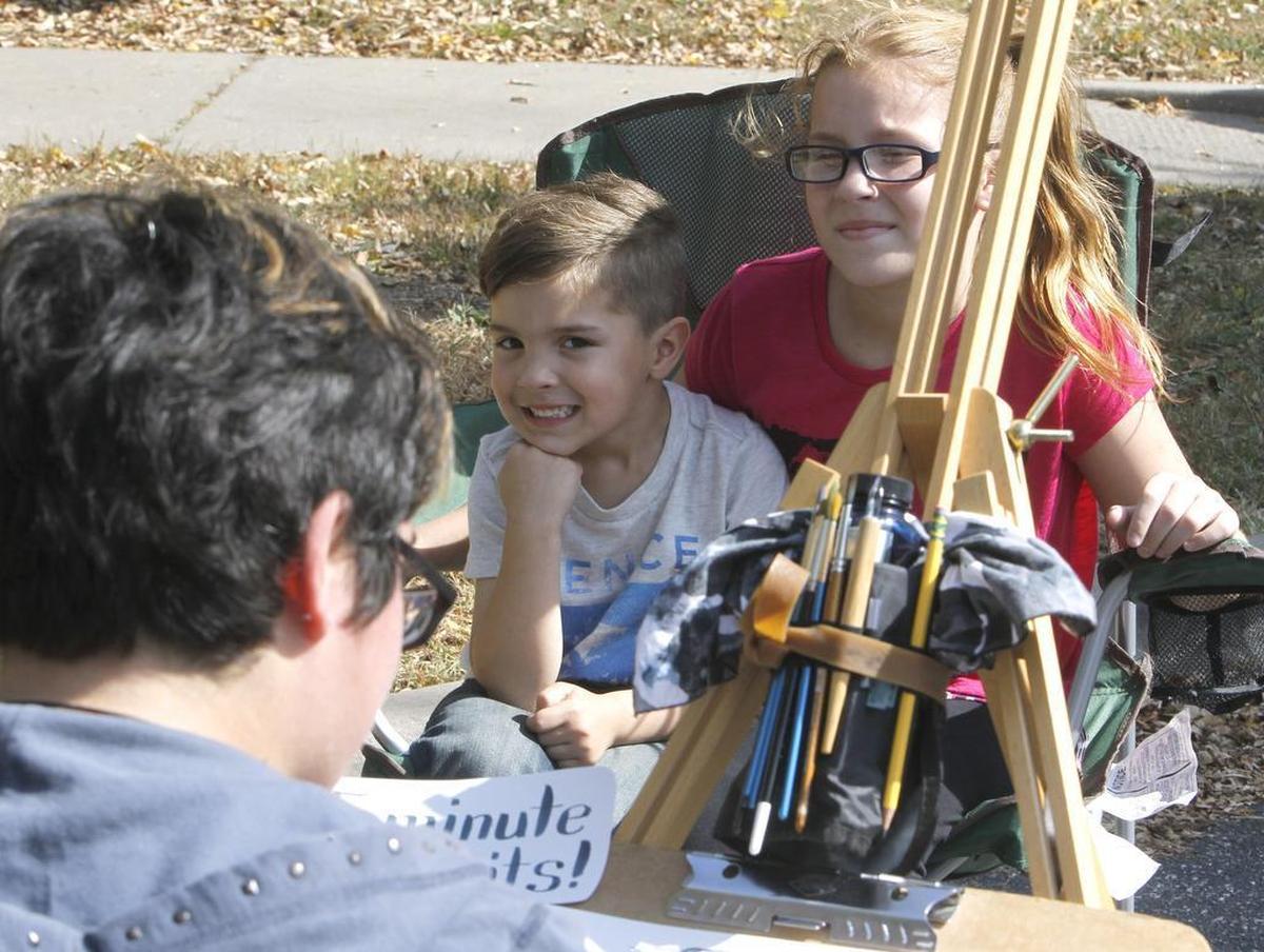 Bryson Dill, 4, and his sister Aubrey Dill, 10, sat still as portrait artist Emily Catedral sketched them during the 2016 BaconFest events in downtown O’Fallon.