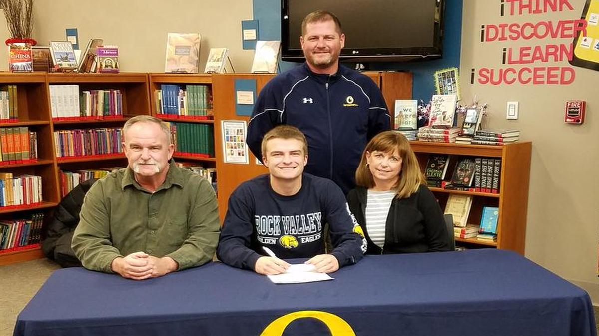 Justin Dye, center, is flanked by his parents, his father, Chuck Dye, and mother, Carol Dye, as he signs his letter of intent to play baseball at Rock Valley College. In the back is Jason Portz, OTHS head baseball coach.