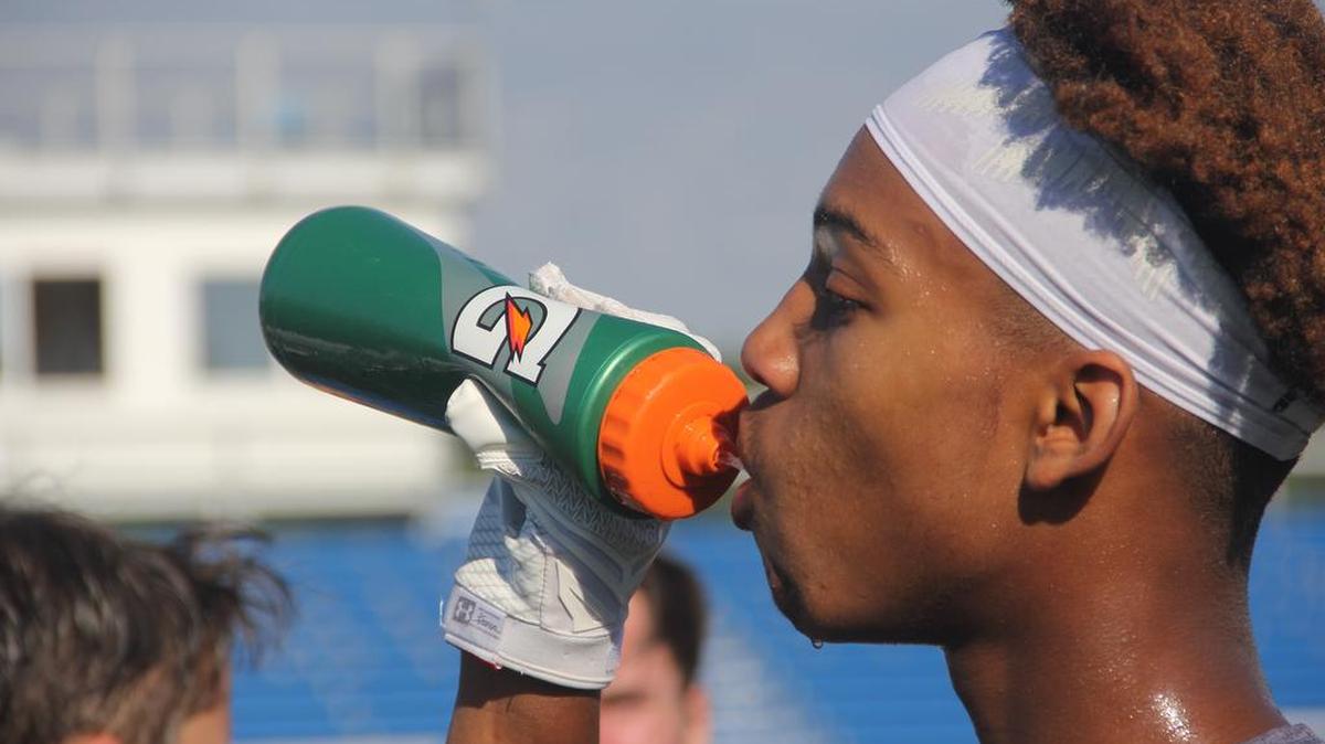 Christian Curtis stays hydrated drinking a bottle of water during Tuesday morning’s practice.