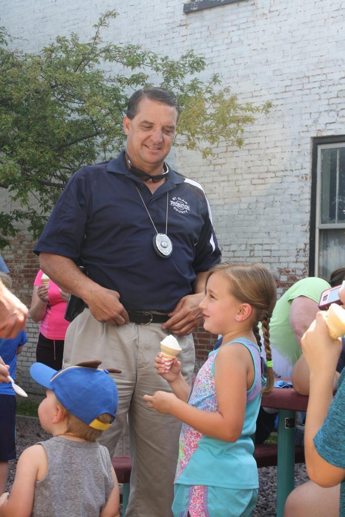 O’Fallon Ward 3 Alderman Kevin Hagarty looks on at kids laughing while enjoying their complimentary ice cream cone during the Cones with a Cop event in 2017. Hagarty, 54, who had represented Ward 3 since 2011, passed away from natural causes Wednesday, March 30.