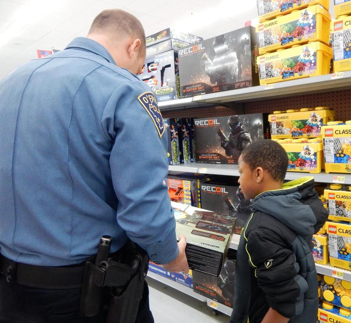 O’Fallon Police Capt. Kirk Brueggeman shops with Jayden, 7, during OPD’s Christmastime Cops and Kids event at Walmart.