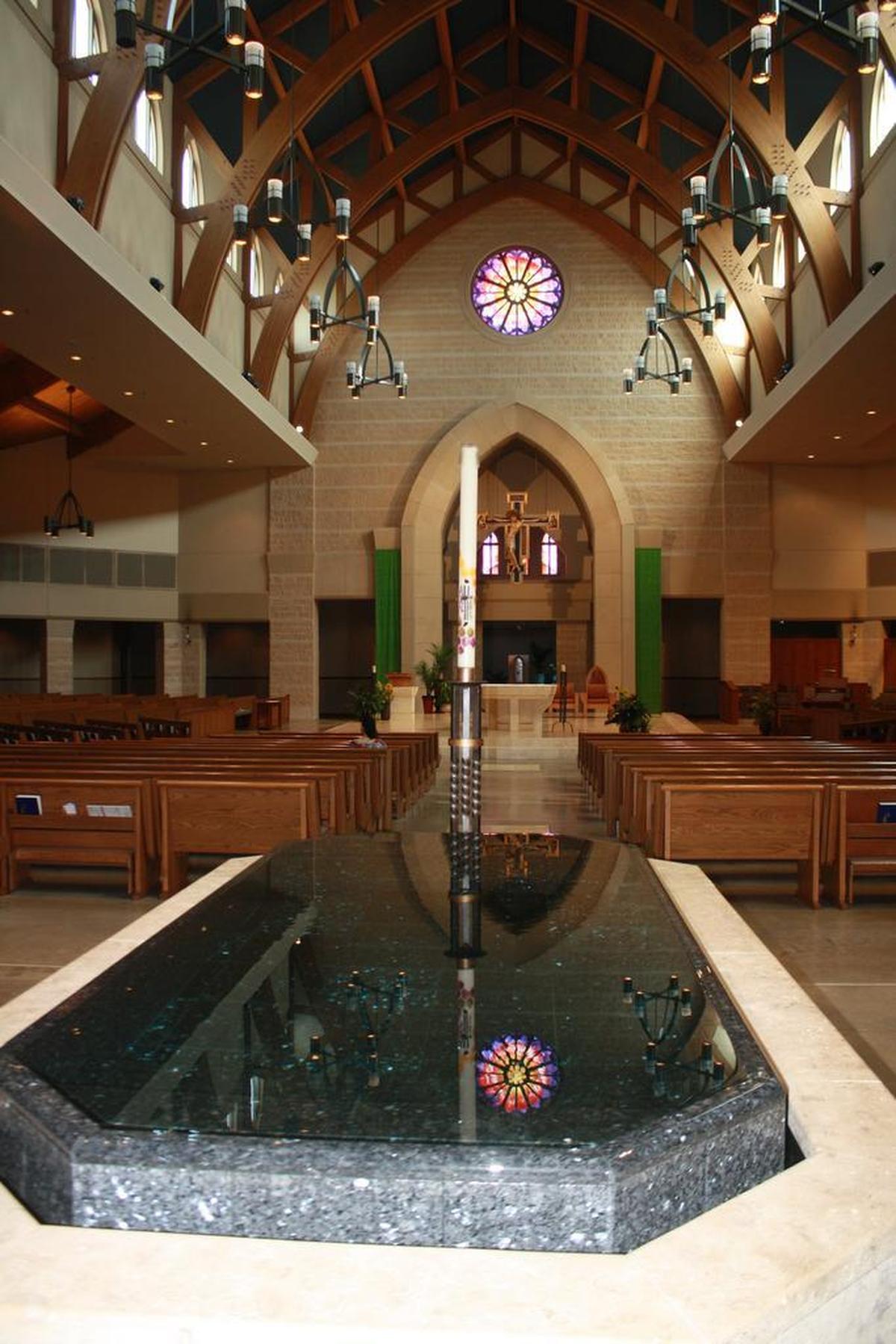 The 100 million-year-old stone baptismal font sits just inside the worship space at St. Clare of Assisi Roman Catholic Church at 1411 Cross St. in O’Fallon. Above the alter is a hand-blown custom glass window made by a female artist in California representing the Cantical of Creation poem by St. Francis where he refers to the sun as ‘Brother Sun’ when praising God’s creation which mirrors another rose architectural window called ‘Sister Moon,’ (which is above the baptismal font and not pictured here.)