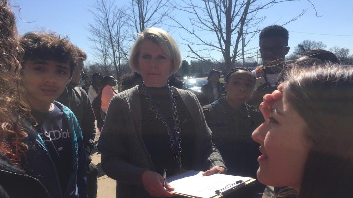 O’Fallon Township High School students protest the District 203 budget cuts on Thursday afternoon outside of the high school. Martha Weld, assistant superintendent talks to student protesters.