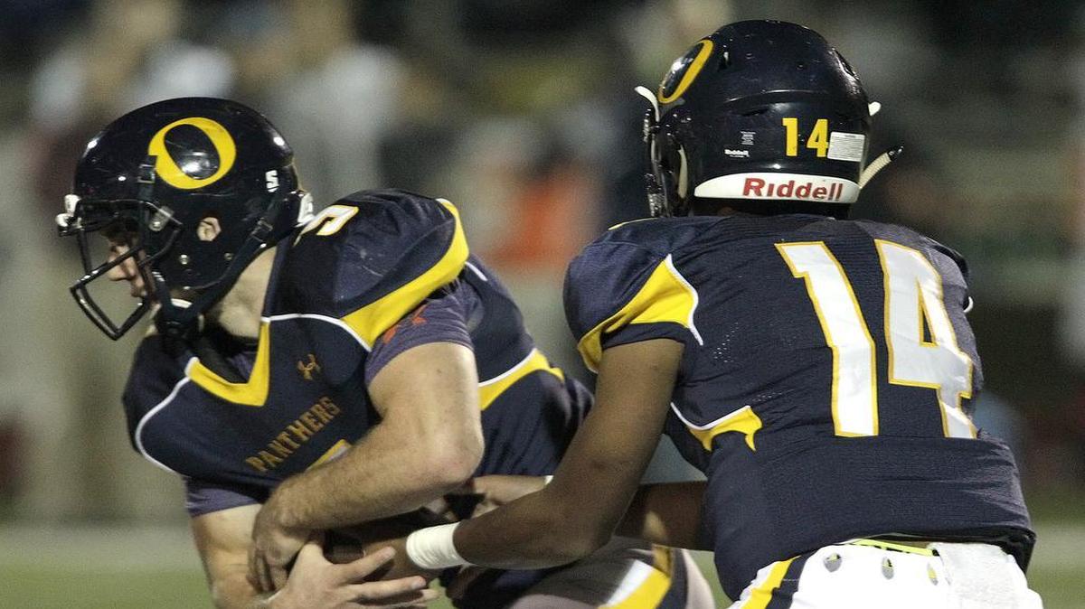 O’Fallon QB Christian Perez (14) hands off to RB Mason Hewitt (5) during a game last month.