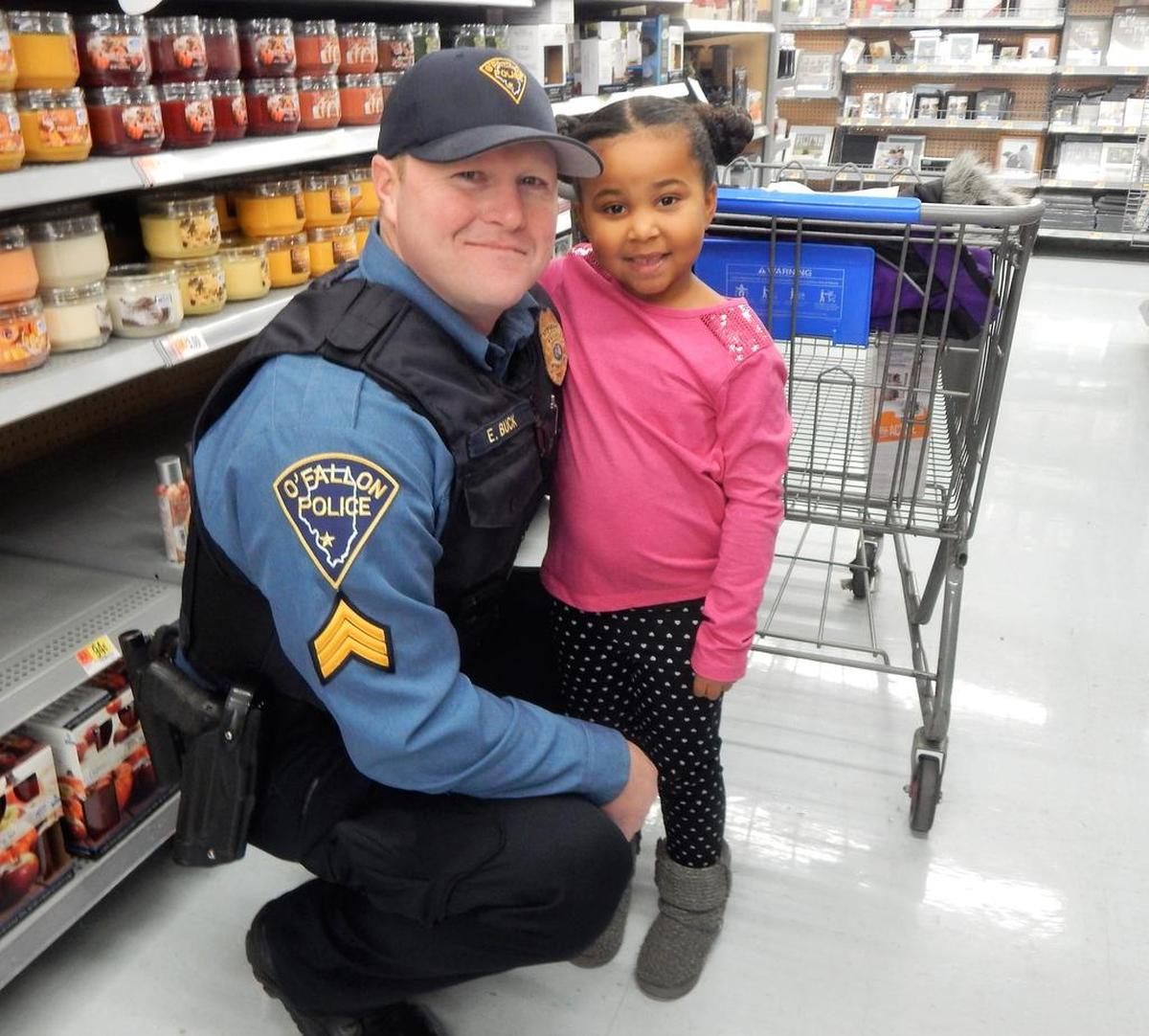 Officer Eric Buck with Skylar, 5, during OPD’s Christmastime Cops and Kids event at Walmart.