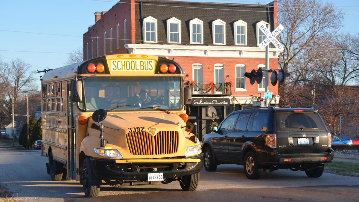 A local O’Fallon school bus crosses the CSX Railroad grade crossing after coming to a complete stop just before the South Oak and West First streets intersection.