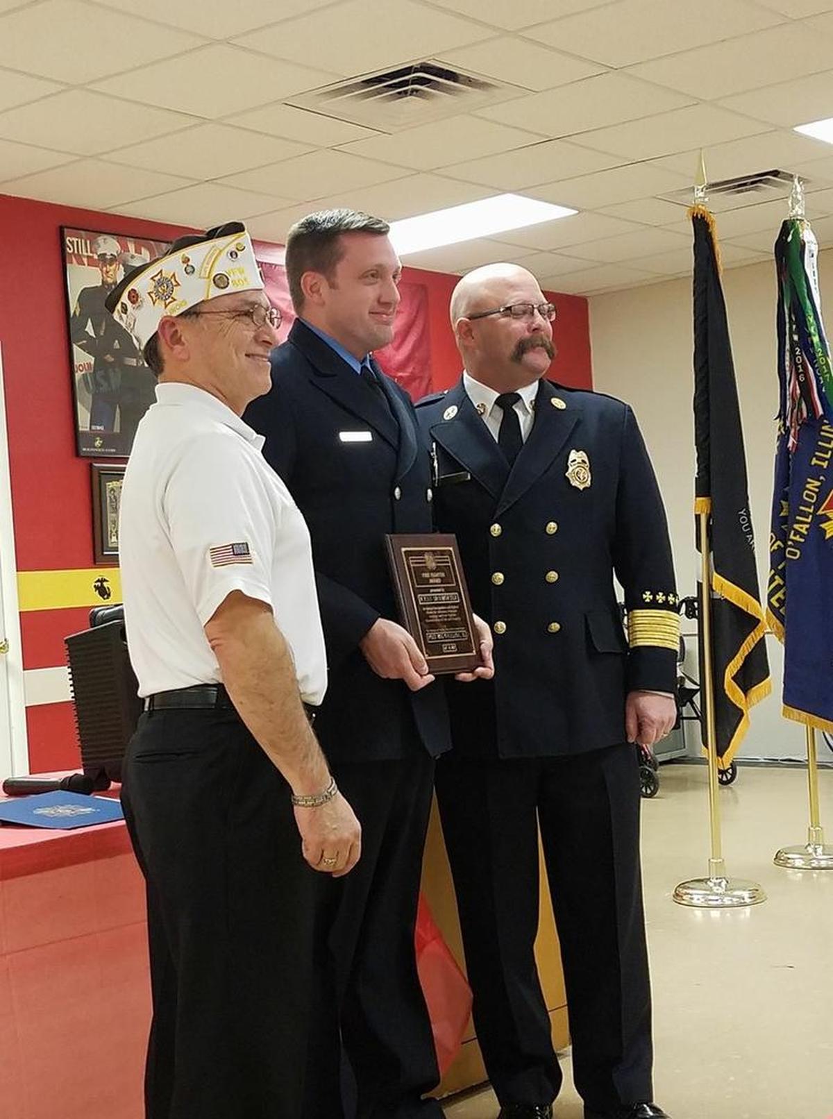 O’Fallon Veterans of Foreign Wars Post 805 Commander Ed Martinez awards O’Fallon Fire Fighter Ryan McWhorter with the VFW National Fire Fighter Public Service Citation Award during the annual VFW First Responder Award Banquet. O’Fallon Fire Chief Brent Saunders stands far right.