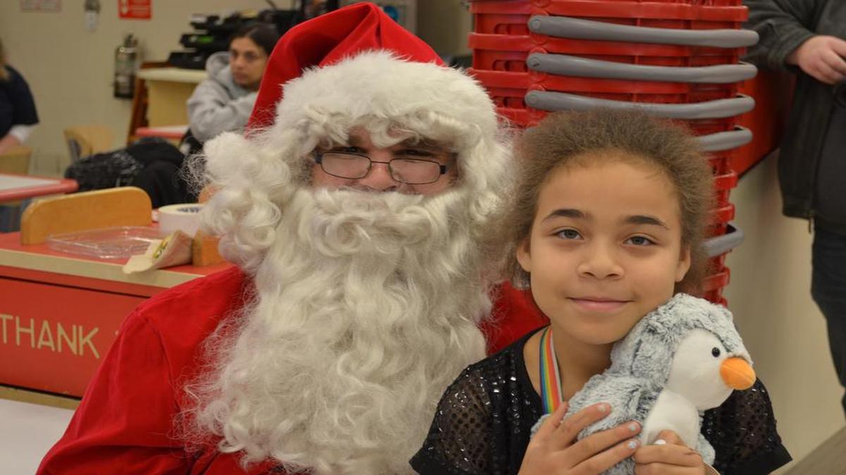 Local O’Fallon-Shiloh area youth Christina Harvey-Ervin sits on Santa Clause’s lap during the first Metro-East Paramedic Association and O’Fallon-Shiloh EMS “Christmas for Kids” holiday shopping event on Saturday, Dec. 17 at the Shiloh’s Green Mount Crossing Target retailer, held for 12 local O’Fallon-Shiloh children chosen by local school administrators and staff.