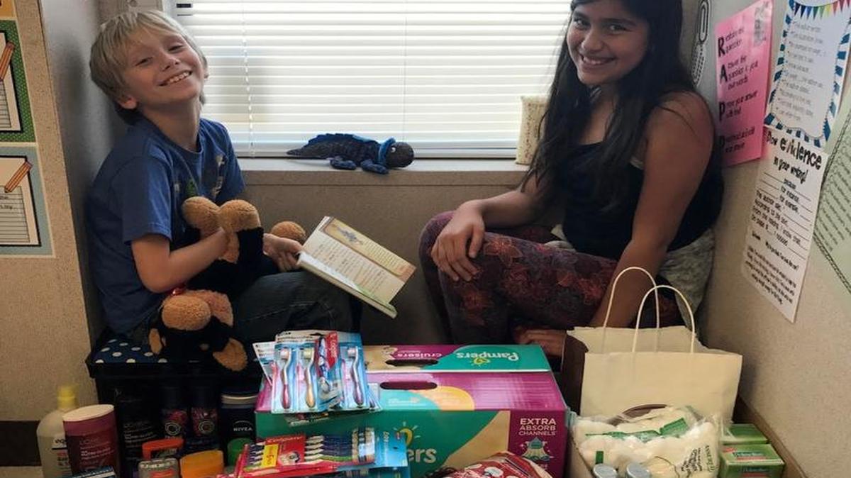 Central Elementary School students Ashton Prewitt and Pricilla Jimenez sit next to some of the many donations for thier Central School District 104 effort to help Texan victims of Hurrican Harvey called ‘Helping Houston.’