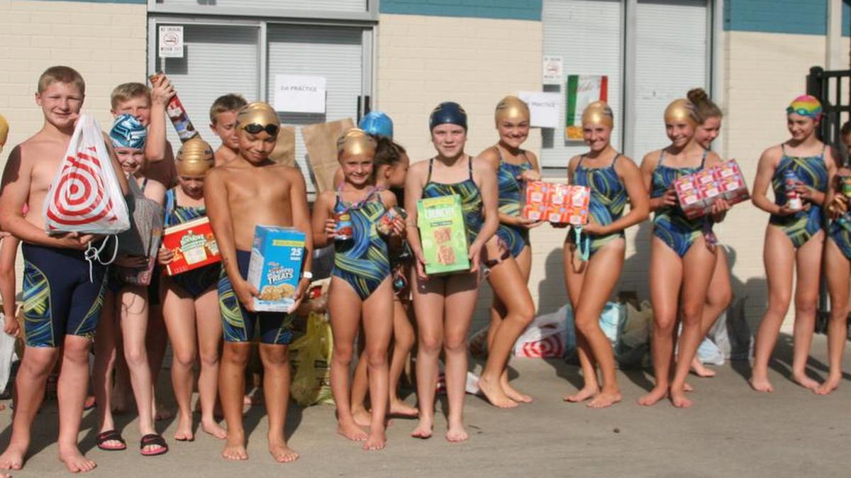 Members of the O’Fallon Breakers Swim Team display items received during their early food drive collection as part of their annual Team H2O project. In the end, the team collected more than 600 can of food and non-perishable items and a bucket of cash for donation to the O’Fallon Food Pantry.