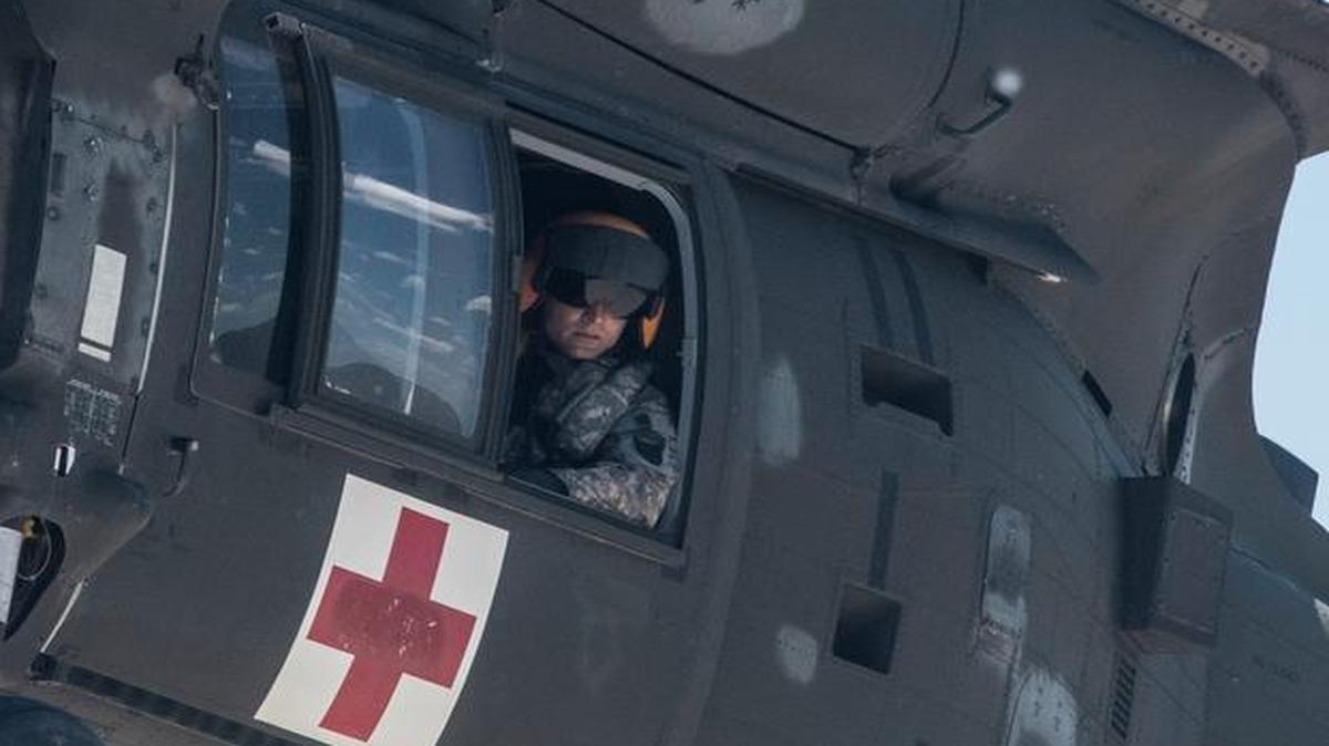An Army member of the 6-101st Aviation Regiment leans out of the window of a UH-60 Black Hawk in this file photo.