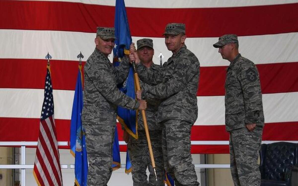 Gen. Mike Holmes, Air Combat Command commander, (right), receives the guidon from Gen. Carlton Everhart, Air Mobility Command commander, (left), during a realignment ceremony at Grand Forks Air Force Base, N.D. Passing the guidon symbolizes the change of the 319th Air Base Wing from AMC, to ACC.