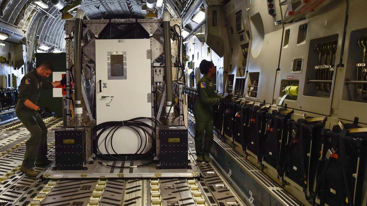 Airman Jeff McGee (left), a 3rd Airlift Squadron loadmaster from Dover Air Force Base, and Senior Airman Kaely Brackett (right), a 3rd AS loadmaster, secure a Transportation Isolation System during Exercise Mobility Solace at Joint Base Charleston, S.C.