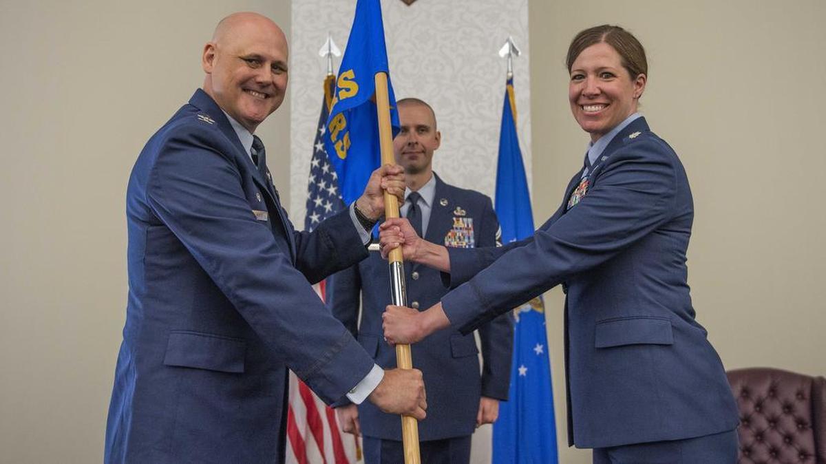 Col. Todd Schug, commander of the 38th Cyberspace Engineering Installation Group at Tinker Air Force Base, Oklahoma, passes the 38th Cyberspace Readiness Squadron guidon to Lt. Col. Tamara Keene during a change of command ceremony July 18 at Scott Air Force Base.