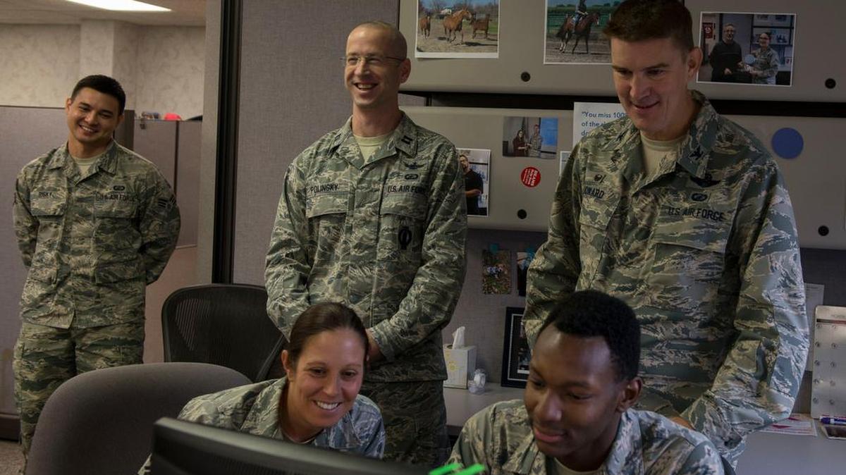 Airman 1st Class Shawn Reid, (seated), 375th Comptroller Squadron budget technician, explains TDY and PCS financing processes to Col. John Howard, 375th Air Mobility Wing commander, and Chief Master Sgt. Patricia Hickey, 375th AMW command chief, on Oct. 31.