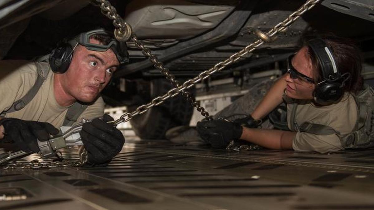 Senior Airman Cole Seelen and Airman 1st Class Holly Cooper, both with the 921st Contingency Response Squadron, strap down a Humvee during exercise Mobility Guardian at Moses Lake, Wash.
