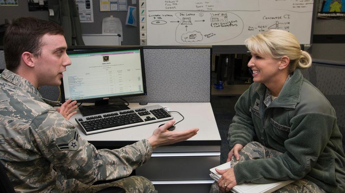 Airman 1st Class Andrew Monroe, 375th Communications Group, briefs Col. Laura Lenderman, 375th Air Mobility Wing Commander, on software testing during a visit to the unit Dec. 1. Moore is responsible for software development.
