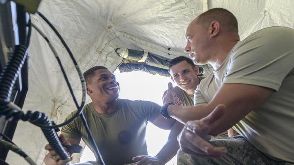 Joint Communication Support Element Operators Marine Corps Sgt. Landon Gilmore, Army Spc. James Hughes and Air Force Staff Sgt. Robert Carlisto perform a radio check with Cherry Point, N.C., after setting up a communications tent during an exercise at MacDill Air Force Base, Fla.