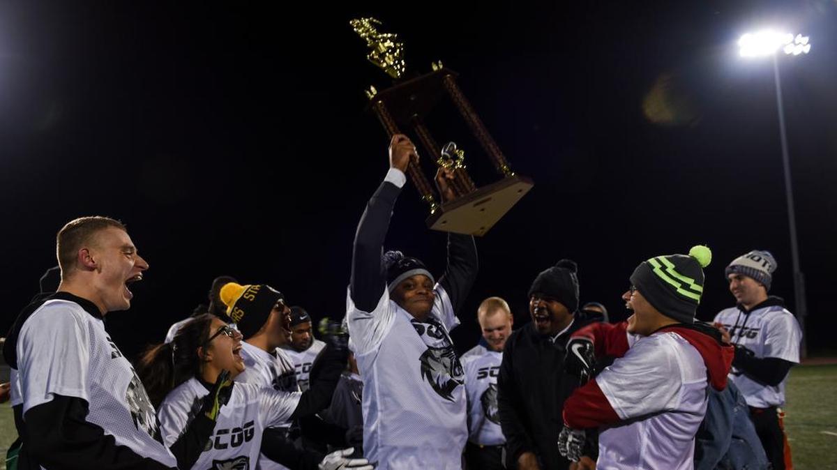 Tech Sgt. Bryant Brown, 635th Supply Chain Operations Wing, raises the trophy as members of the 635th Supply Chain Operations Group celebrate winning the 2018 Intramural Flag Football Championship Nov. 8 at Scott Air Force Base. The 635th SCOG team out-battled the 375th Force Support Squadron team, winning 32-20, while avenging a loss in last year’s championship game. Photo by Airman 1st Class Chad Gorecki